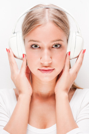Portrait of a gorgeous young blond woman wearing headphones.の写真素材
