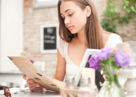 Attractive young brunette having dinner in a fancy restaurant.の写真素材