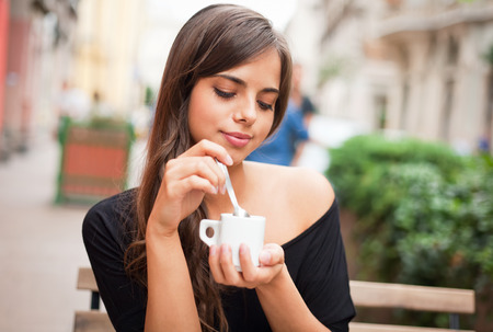 Gorgeous brunette tourist girl having coffee on the street.の写真素材