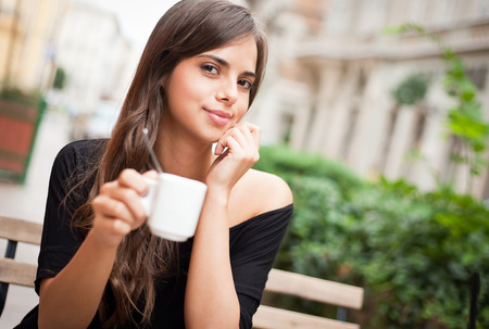 Beautiful young brunette tourist woman enjoying coffee.の写真素材