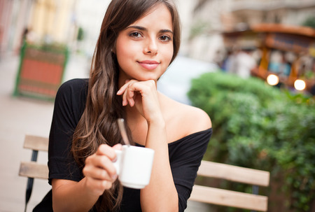 Gorgeous brunette tourist girl having coffee on the street.の写真素材