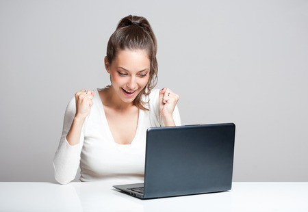 Attractive young brunette woman using her laptop.の写真素材