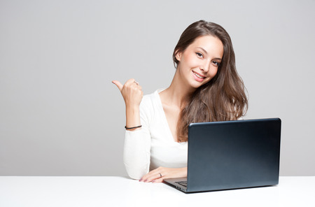 Portrait of a young brunette beauty with her laptop.の写真素材