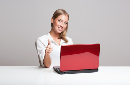 Portrait of a young blond beauty with her laptop.の写真素材