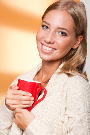Gorgeous young blond relaxing with a cup of hot beverage.の写真素材
