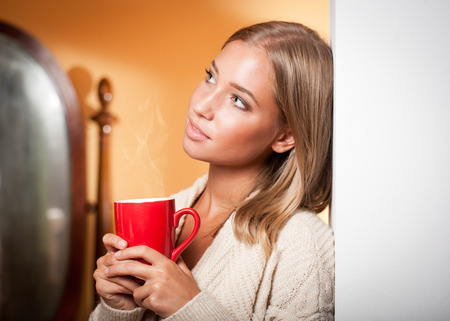 Gorgeous young blond relaxing with a cup of hot beverage.の写真素材