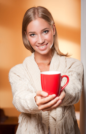 Gorgeous young blond relaxing with a cup of hot beverage.の写真素材