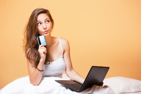 Portrait of a gorgeous young brunette using laptop.の写真素材