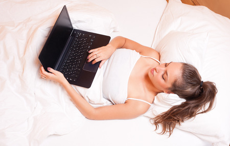 Portrait of a gorgeous young brunette using laptop.の写真素材