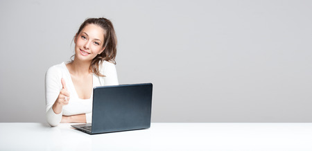Portrait of a young brunette beauty with her laptop.の写真素材