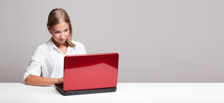 Portrait of a blond beauty using laptop computer.の写真素材