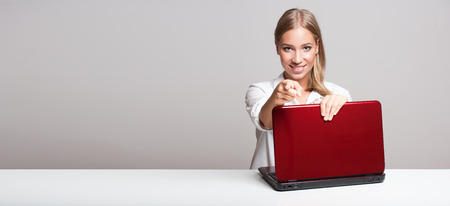 Portrait of a blond beauty using laptop computer.の写真素材