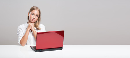 Portrait of a blond beauty using laptop computer.の写真素材