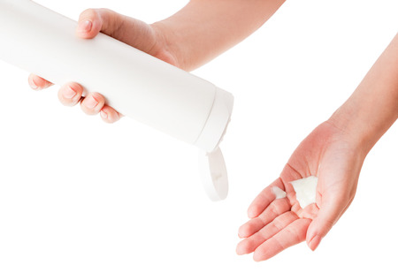 Female hands applying body lotion on white background.の写真素材