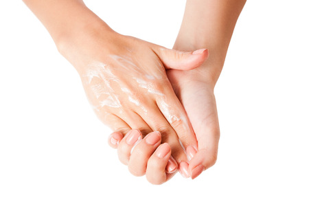Female hands using body lotion, isolated on white background.の写真素材