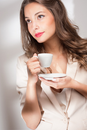 Portrait of gorgeous young brunette woman holding cup of coffee.の写真素材