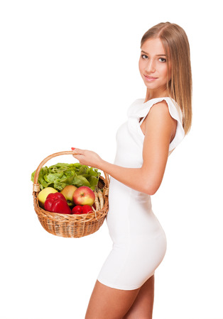Fit gorgeous young blond woman holding wicker basket full of fresh vegetables.の写真素材