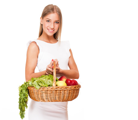 Fit gorgeous young blond woman holding wicker basket full of fresh vegetables.の写真素材