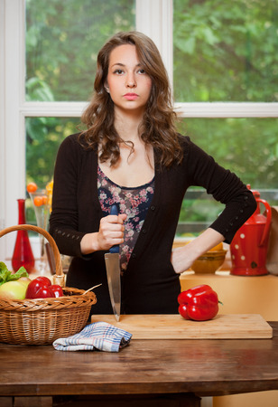 Gorgeous young brunette woman in the kitchen with basket full of healthy food.の写真素材