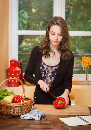 Fit brunette beauty preparing healthy food in the kitchen.の写真素材