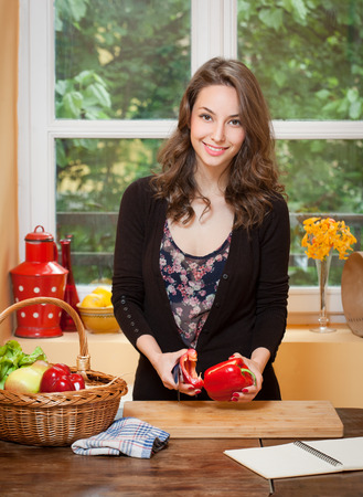 Portrait of a gorgeous brunette preparing healthy meal in the kitchen.の写真素材