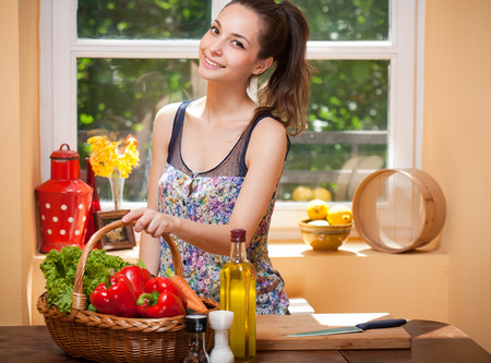 Portrait of a gorgeous brunette preparing healthy meal in the kitchen.の写真素材