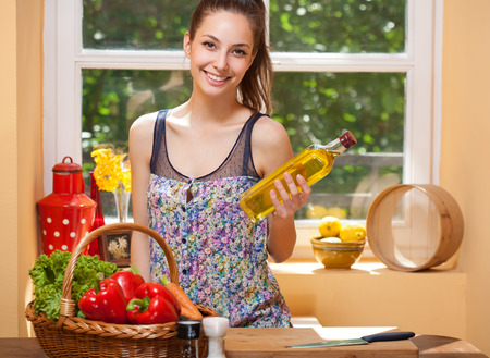 Fit brunette beauty preparing healthy food in the kitchen.の写真素材