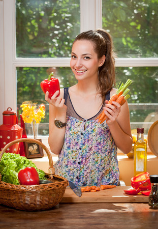 Portrait of a gorgeous brunette preparing healthy meal in the kitchen.の写真素材