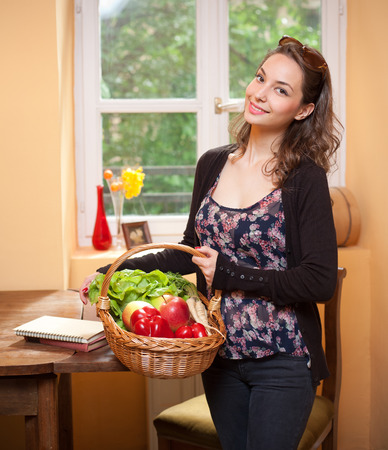Gorgeous young brunette woman in the kitchen preparing healthy ingredients.の写真素材