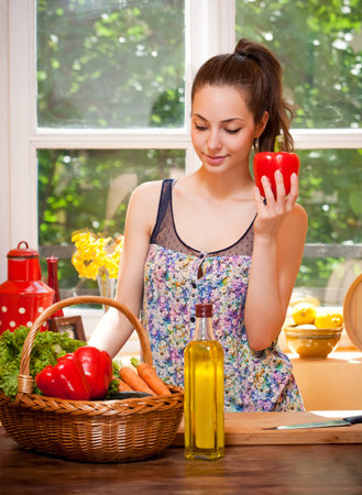 Gorgeous young brunette woman in the kitchen preparing healthy ingredients.の写真素材