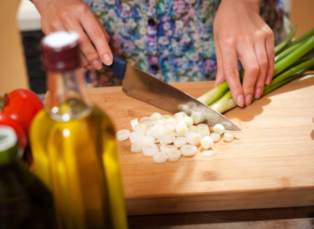 Beautiful young brunette woman preparing healthy food in the kitchen.の写真素材