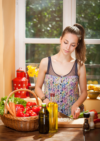 Gorgeous young brunette woman in the kitchen preparing healthy ingredients.の写真素材