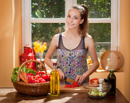 Gorgeous young brunette woman in the kitchen preparing healthy ingredients.の写真素材