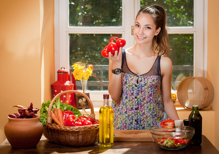 Gorgeous young brunette woman in the kitchen preparing healthy ingredients.の写真素材