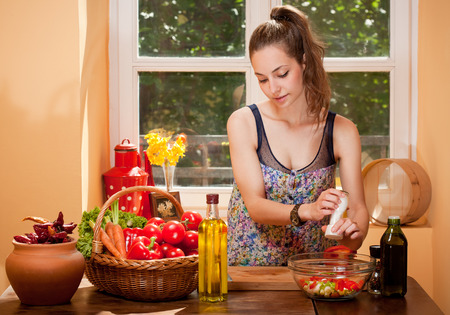 Gorgeous young brunette woman in the kitchen preparing healthy ingredients.の写真素材