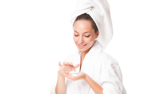 Portrait of a brunette beauty applying moisturizer on her skin.の写真素材