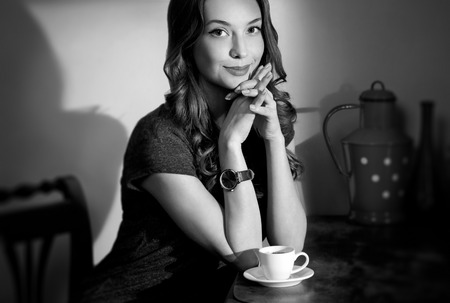 Vintage style portrait of gorgeous brunette with cup of espresso.の写真素材