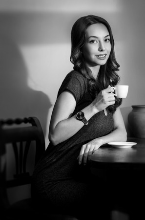 Portrait of brunette beauty having coffee in vintage black and white style.の写真素材