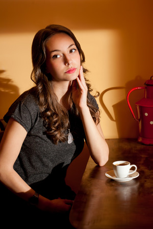 Portrait of young brunette beauty having a cup of coffee.の写真素材