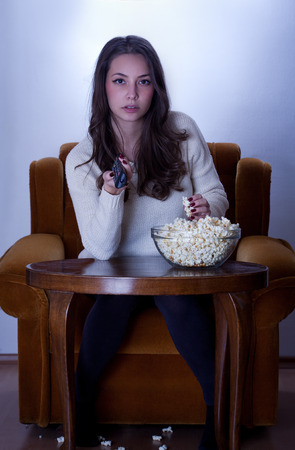 Portrait of young brunette in front of the television.の写真素材