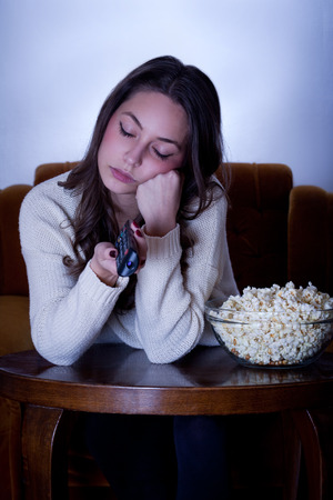 Portrait of young brunette in front of the television.の写真素材