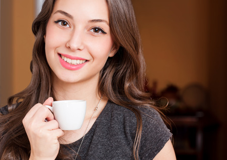 Portrait of a gorgeous young brunette woman having coffee.の写真素材