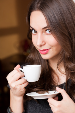Portrait of a gorgeous young brunette woman having coffee.の写真素材