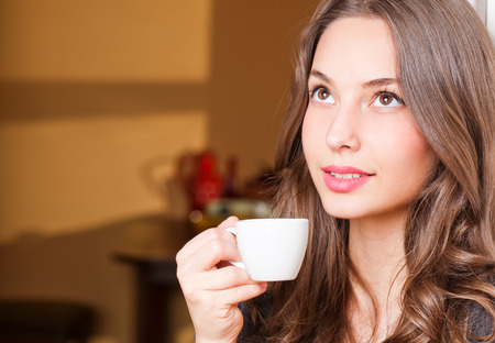 Portrait of a gorgeous young brunette woman having coffee.の写真素材