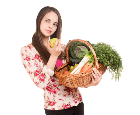 Portrait of cute young brunette with a basket of healthy groceries.の写真素材