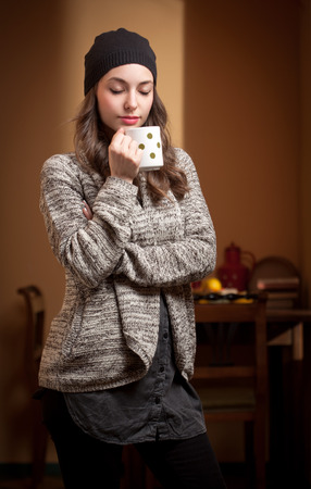 Portrait of a gorgeous young brunette relaxing with cup of hot beverage.の写真素材