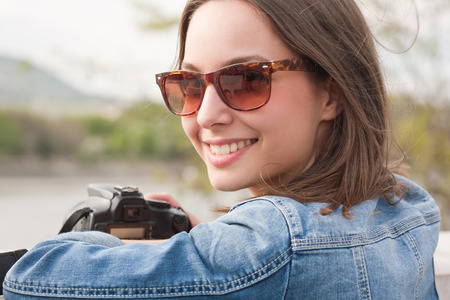 Beautiful happy young brunette taking photographs.の写真素材