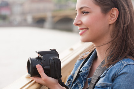 Beautiful happy young brunette taking photographs.の写真素材