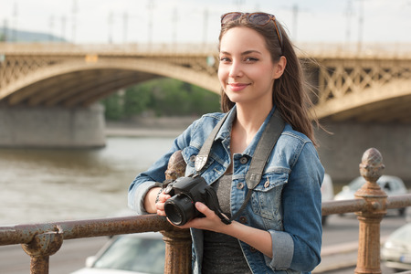 Beautiful happy young brunette taking photographs.の写真素材