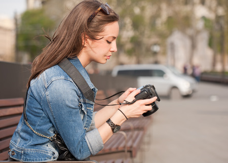 Beautiful happy young brunette taking photographs.の写真素材